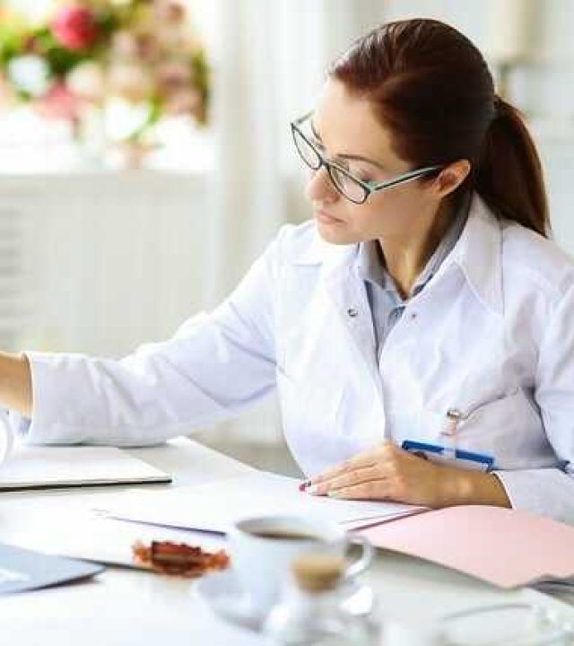 Kobieta przy biurku z dokumentami – ilustracja potrzeby ubezpieczenia OC zawodowego dla osób wykonujących odpowiedzialną pracę